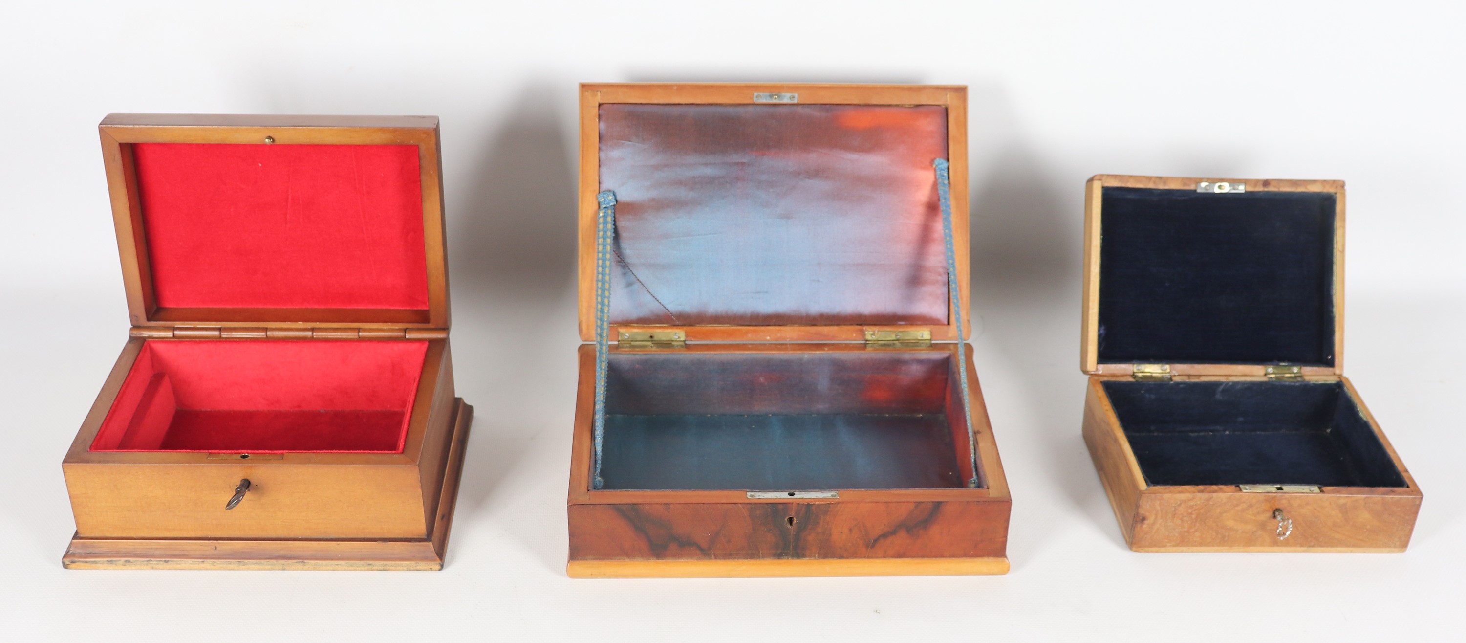 Lotto di tre scatole in noce, di cui una con intarsi sul coperchio