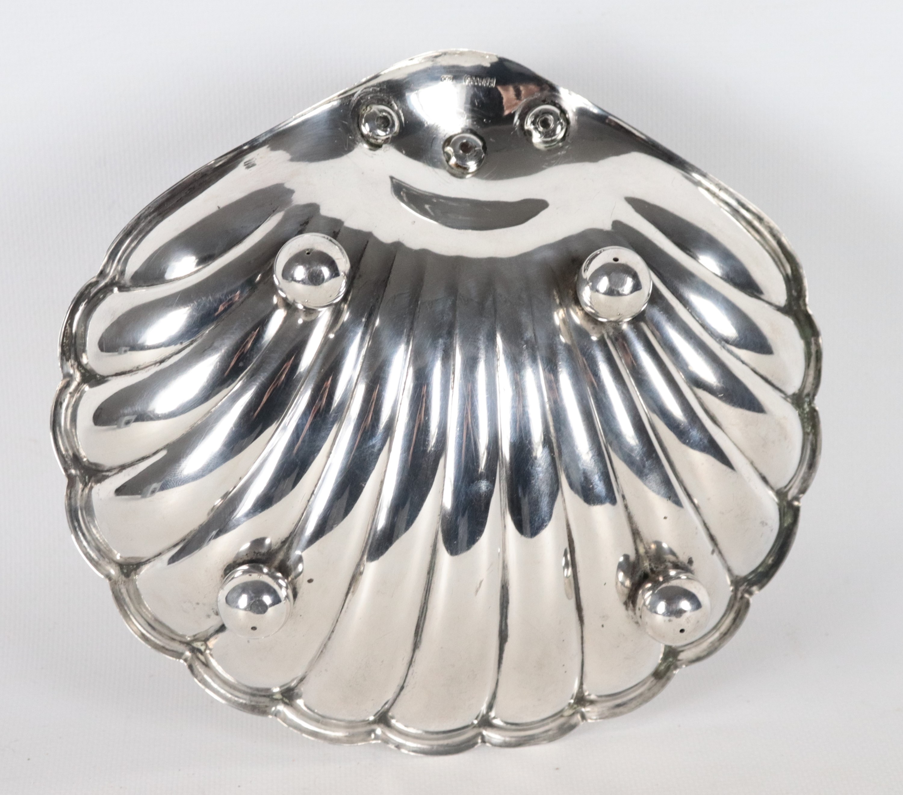 Grande conchiglia in argento cesellato e sbalzato, sorretta da quattro piedini a sfera, gr. 480