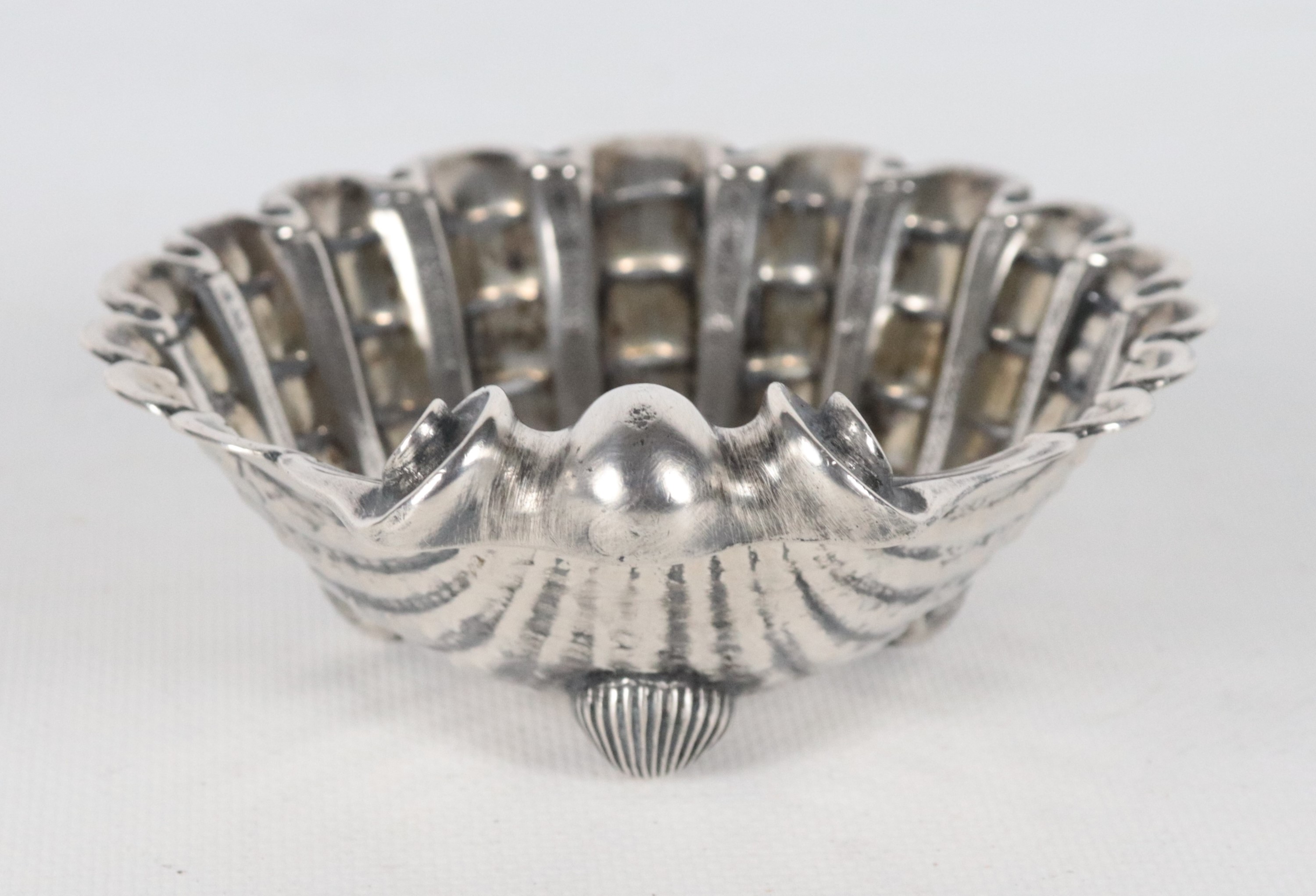 Conchiglia in argento cesellato e sbalzato, sorretta da tre piedini, gr. 185