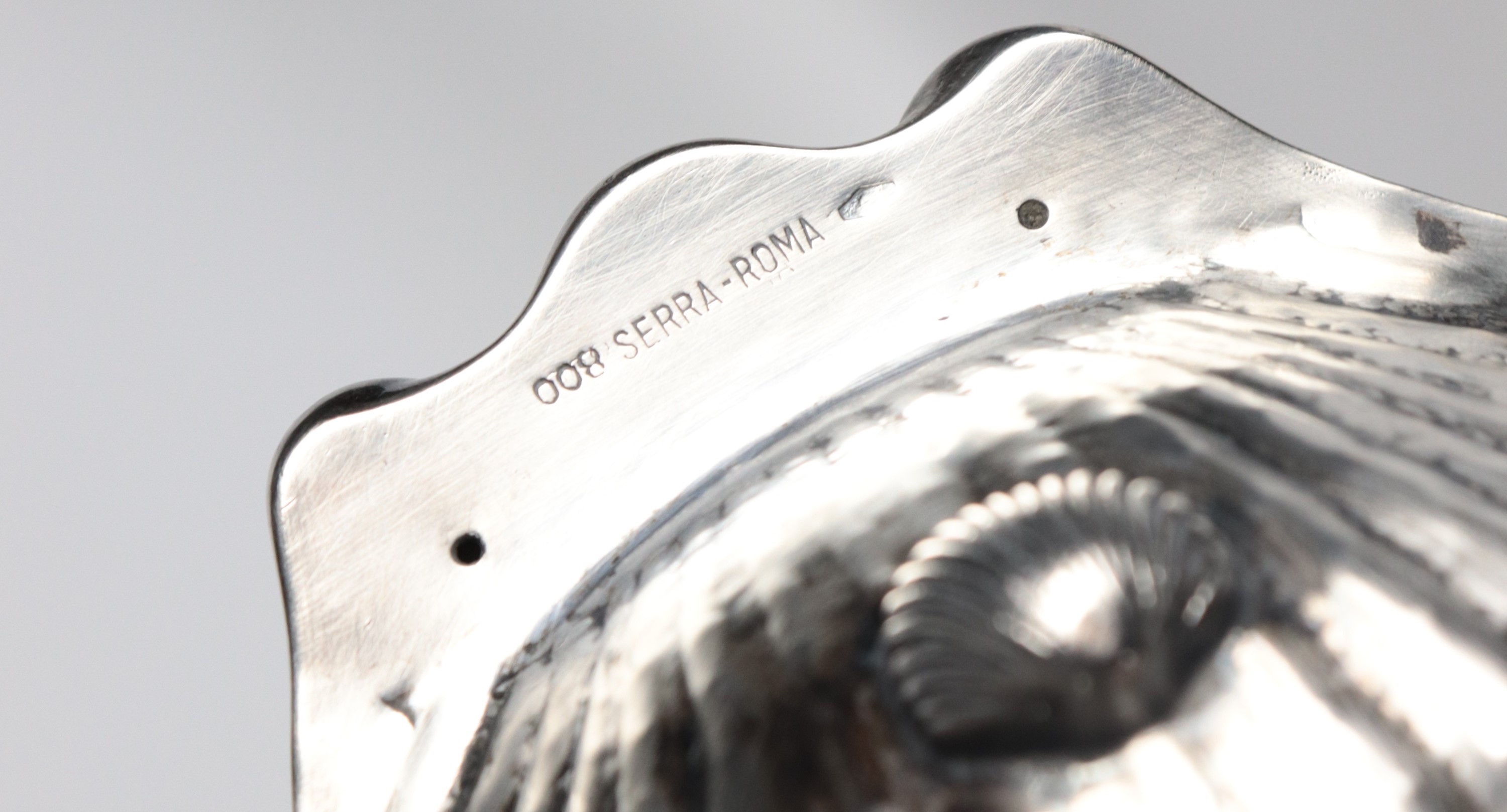 Conchiglia in argento cesellato e sbalzato, sorretta da tre piedini, gr. 185