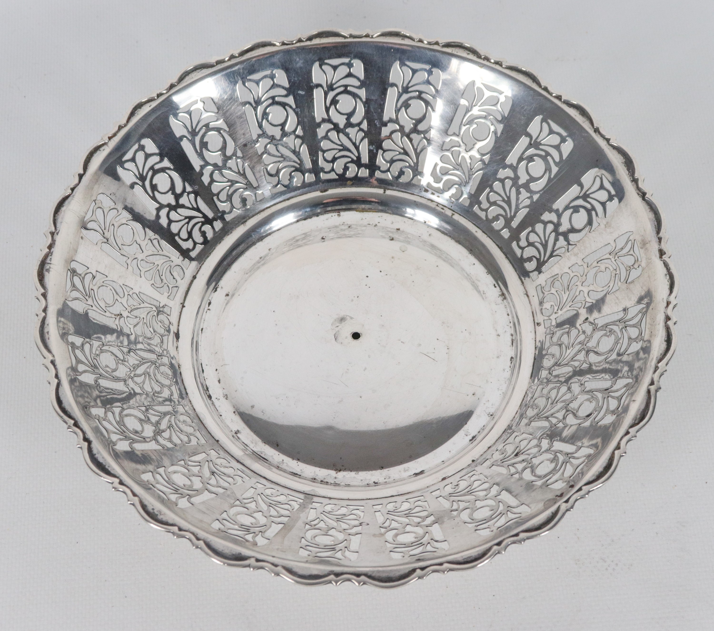 Centrotavola tondo in argento, con bordo centinato, sbalzato e traforato, gr. 255