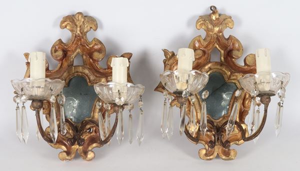 Pair of antique wall lamps made up of small gilded and carved wooden scrolls with Louis XIV motifs