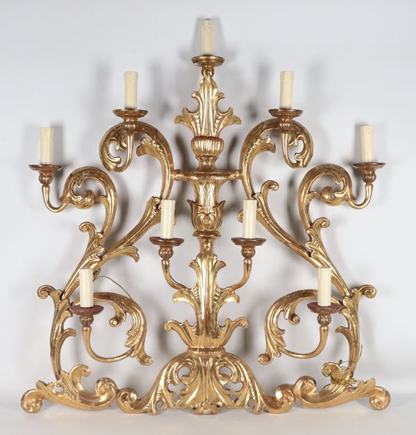 Antique large wall light in gilded wood and carved with Louis XIV motifs of scrolls, curls and friezes, 9 lights