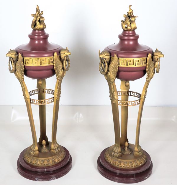 A pair of large antique French tripods in gilded bronze, embossed, chiseled, and lacquered in purple, with legs featuring griffin sculptures. Bases in red French marble.