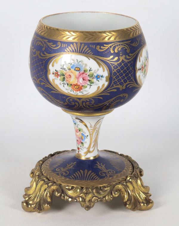 French blue and white porcelain cup, with polychrome decorations featuring medallions of bunches of flowers and highlights in pure gold, gilded bronze base