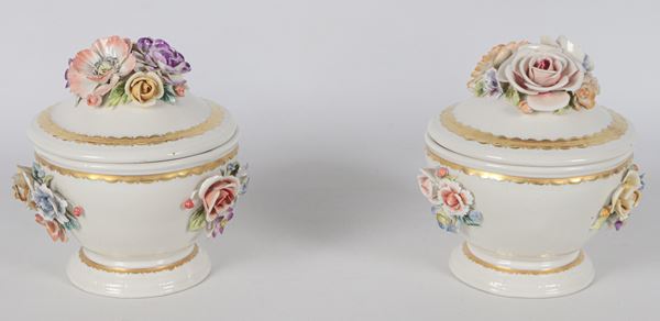 Pair of small potiches with lids in white Capodimonte porcelain, with bunches of polychrome flowers in relief