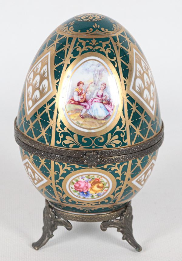 French porcelain egg entirely decorated and multicoloured with floral motifs and romantic scenes, three-legged base in burnished metal