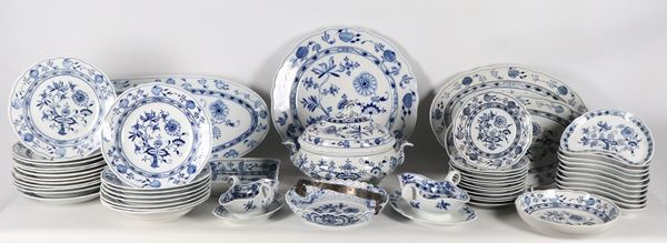 Porcelain dinner service with Onion decoration by the Karl Teichert Factory which used the Meissen brand with the writing in an oval circle and a five-pointed star underneath from 1882 to 1929. The large gravy boat and the basket with metal handle have the Meissen brand with two crossed swords (91 pieces)