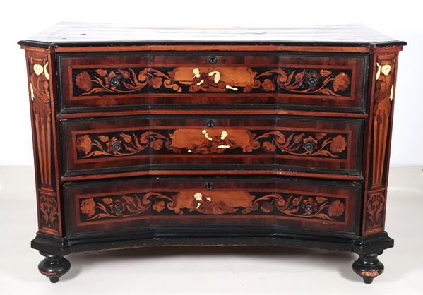 A Lombard-Venetian chest of drawers from the Louis XV era, with a curved shape, made of walnut and various fine woods, inlaid with floral scrolls, female figures, and flowers. The profiles and legs are ebonized.