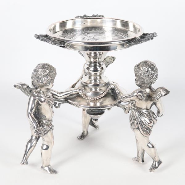 Stand in metal and silvered bronze, with three sculptures of cherubs holding a round bowl