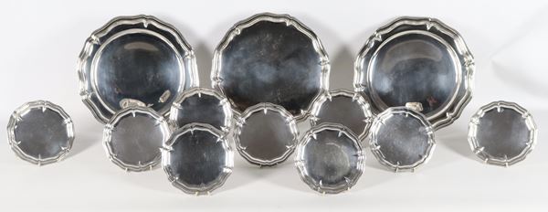 Lot of three round serving plates and nine small plates in chiseled and embossed silver-plated metal with shaped edges (12 pcs.)