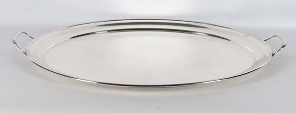 Large oval serving tray in silver metal with two handles and a raised edge