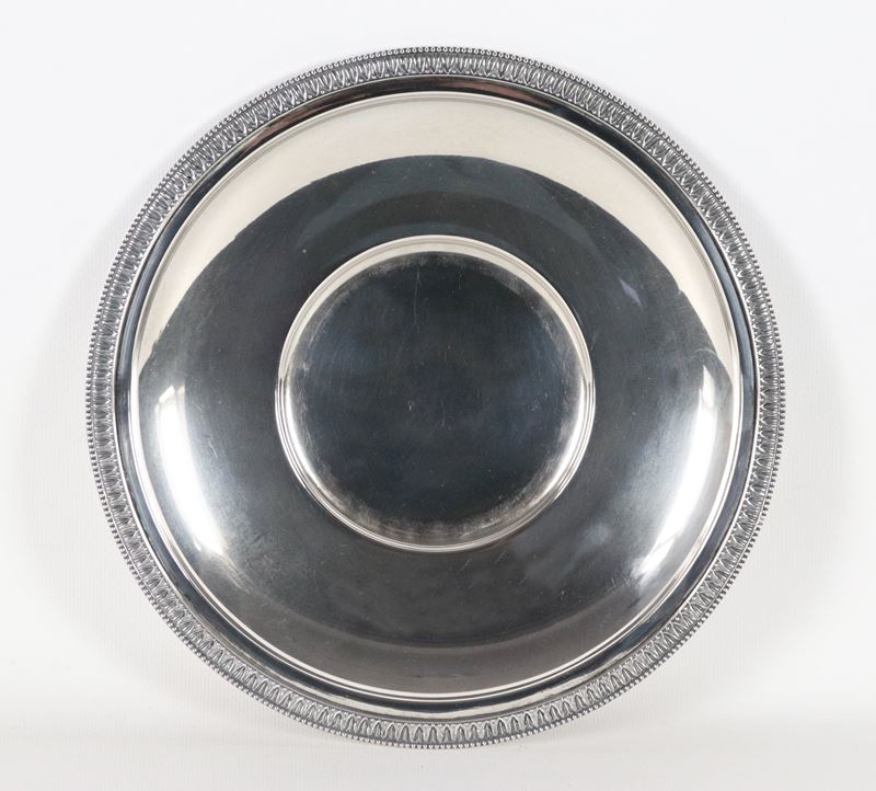Piatto tondo in argento con bordo cesellato e sbalzato a motivi Impero, fondo concavo, gr. 410