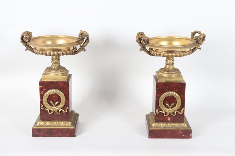 Coppia di antiche coppe francesi Impero in bronzo dorato, sbalzato e cesellato, sorrette da basi ...