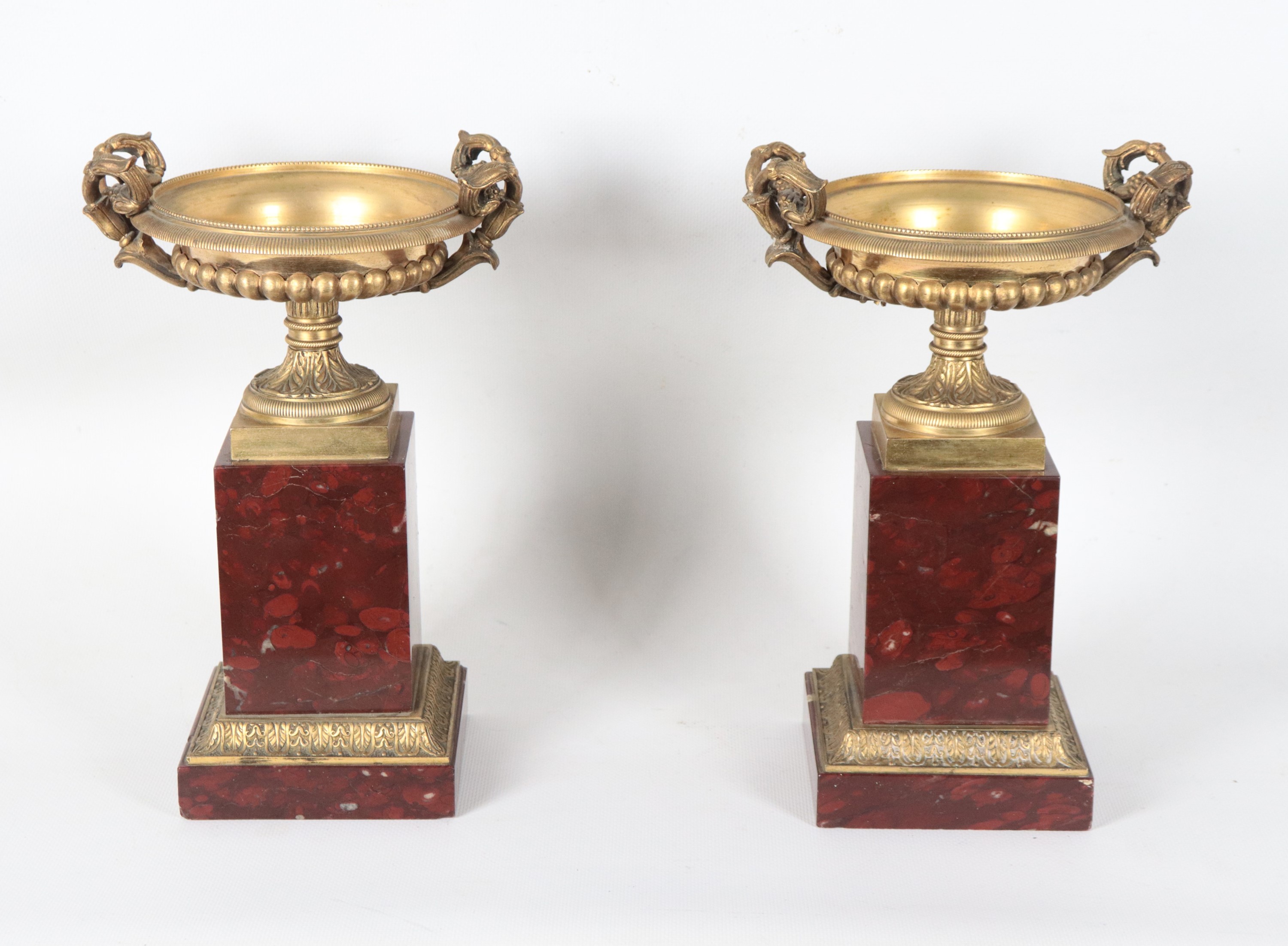 Coppia di antiche coppe francesi Impero in bronzo dorato, sbalzato e cesellato, sorrette da basi ...