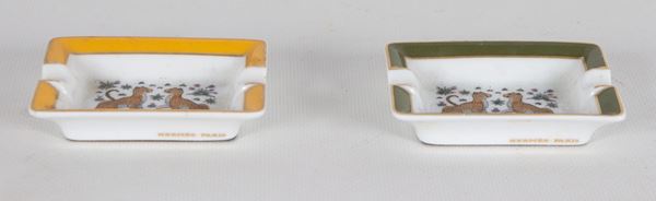 Coppia di piccoli posacenere in porcellana policroma, sul fondo figure di leopardi