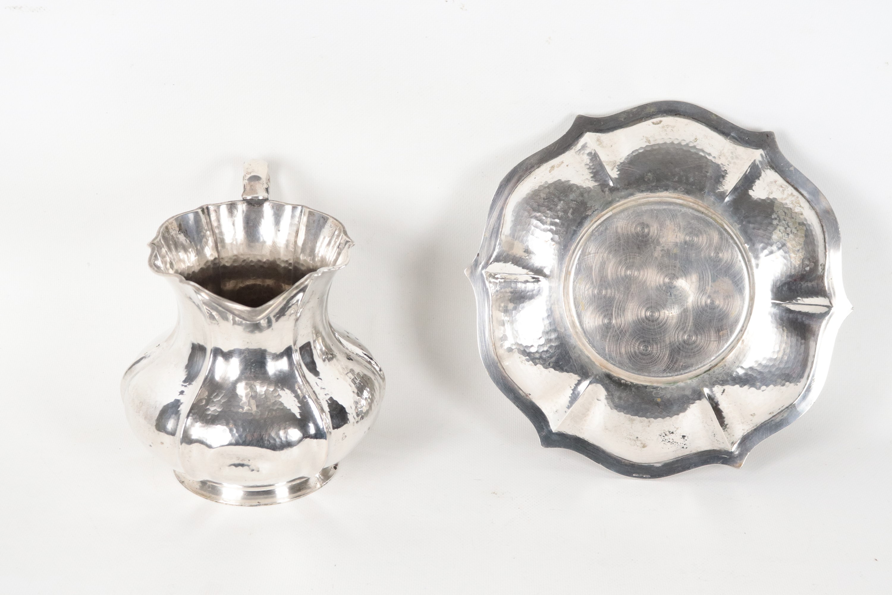 Brocca in argento martellato e sbalzato con sottopiatto, gr. 935