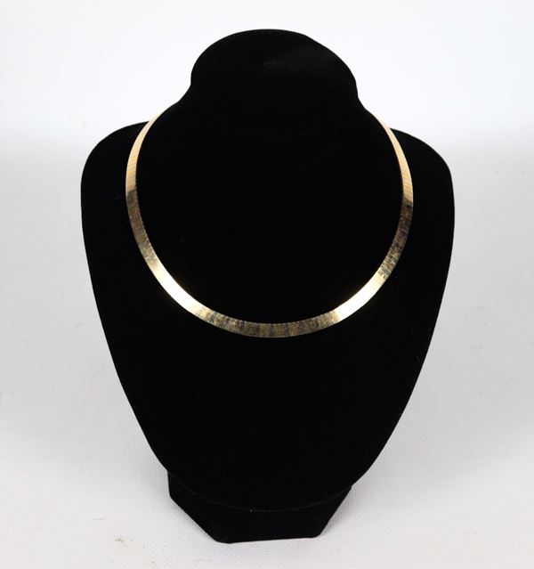 Collana girocollo a maglia rigida in oro 18kt a tre colori. Peso gr. 45