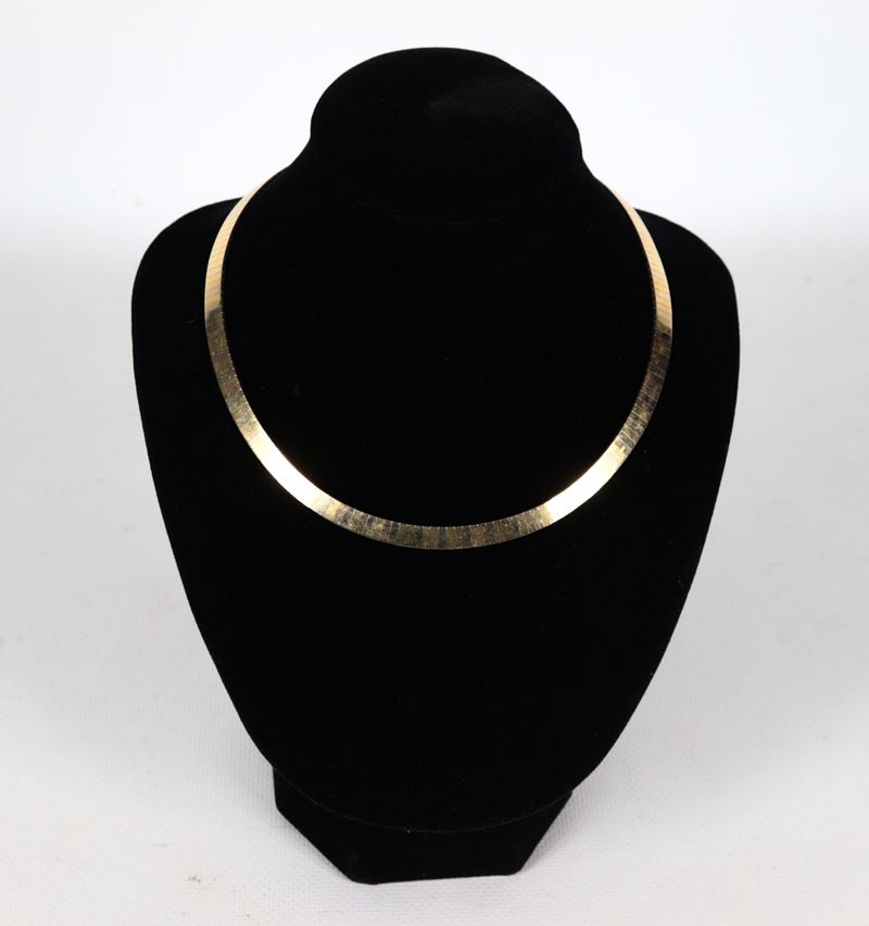 Collana girocollo a maglia rigida in oro 18kt a tre colori. Peso gr. 45