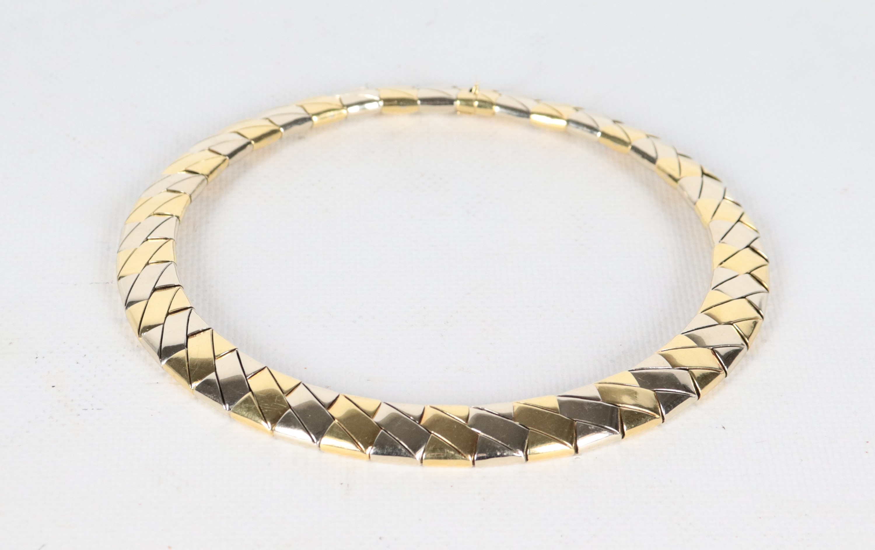 Collana girocollo a elementi snodati in oro 18kt a tre colori. Peso gr. 114,5