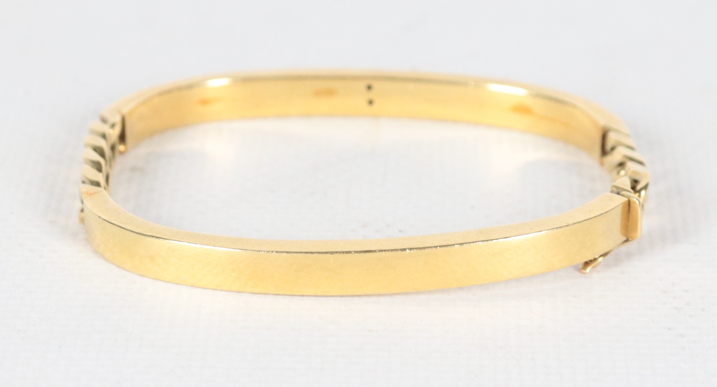 Bracciale a manetta in oro giallo 18kt con smalto rosso e due piccoli diamanti huit-huit. Peso lo...