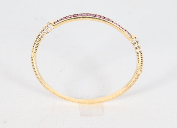 Bracciale a manetta in oro giallo 18kt con piccoli diamanti ct 0,20 circa e rubini taglio carrè. Peso lordo gr. 18