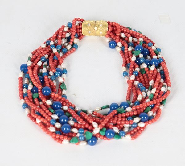Collana torchon a quattordici fili di perle di fiume, coralli e pietre blu e verdi, con chiusura in oro giallo 18kt e piccoli zirconi. Peso totale gr. 24,5