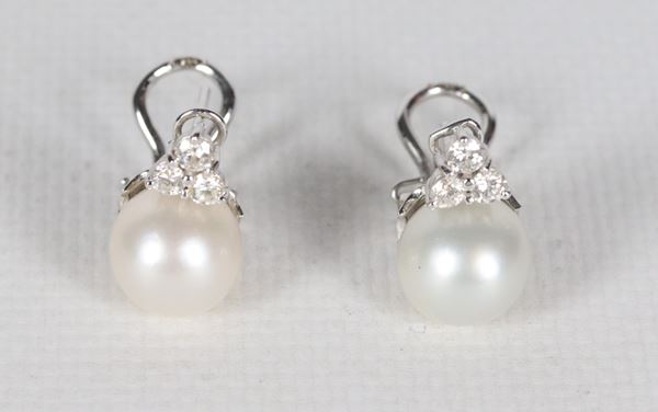 Coppia di orecchini in oro bianco 18kt, con perle coltivate 8 mm circa e sei piccoli diamanti taglio brillante ct 0,50 circa. Peso lordo gr. 10
