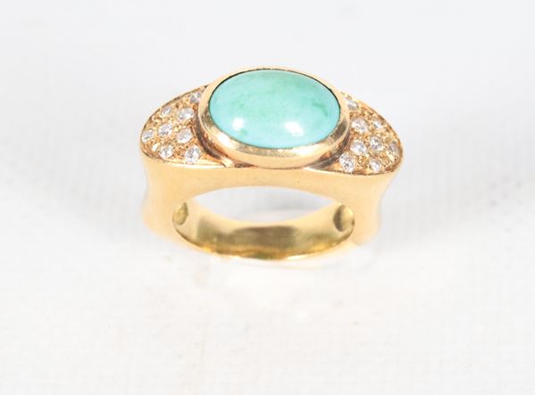 Anello in oro giallo 18kt, con turchese centrale e piccoli diamanti laterali taglio brillante ct 0,25 circa. Peso lordo gr. 15
