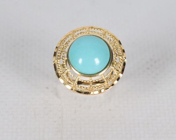 Anello in oro giallo 18kt, con lavorazione traforata  e pasta di turchese centrale. Peso lordo gr. 5,5