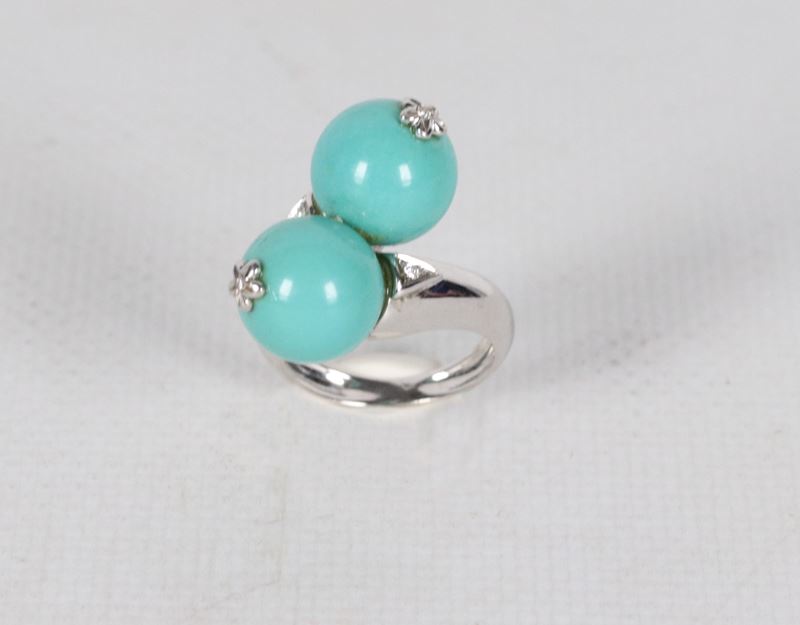 Anello contrariè in oro bianco 18kt, con due turchesi e piccoli diamanti. Peso lordo gr. 10