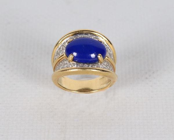 Anello in oro giallo 18kt, con pietra blu centrale taglio cabochon e piccoli diamanti taglio brillante. Peso lordo gr. 12,5
