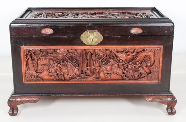 Cassapanca cinese in legno ebanizzato e legno di canfora, con pannelli intagliati a rilievo con scene di battaglia
