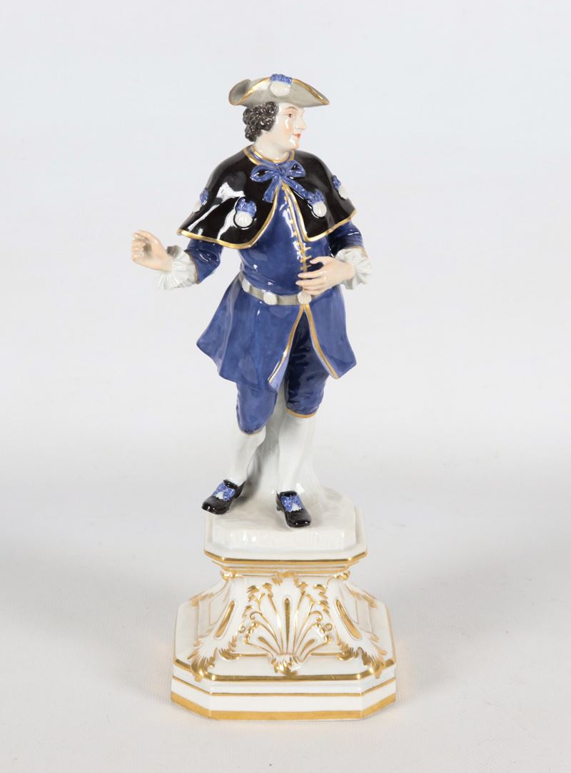 "Cavaliere con mantella", antica piccola scultura in porcellana policroma Meissen, sorretta da ba...