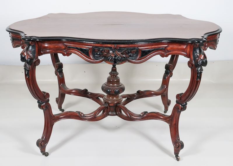 Antico tavolo a rognon Luigi Filippo in noce, con piano ovale sagomato ed intagli ebanizzati a mo...