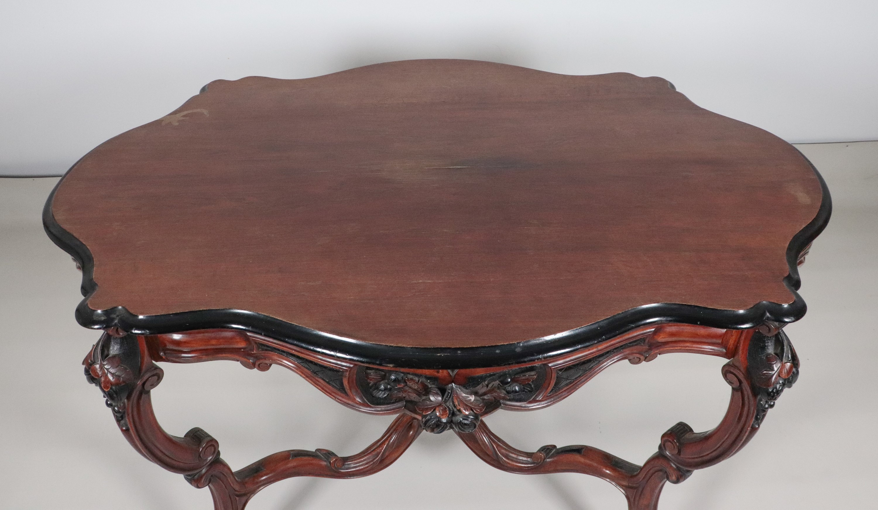 Antico tavolo a rognon Luigi Filippo in noce, con piano ovale sagomato ed intagli ebanizzati a mo...
