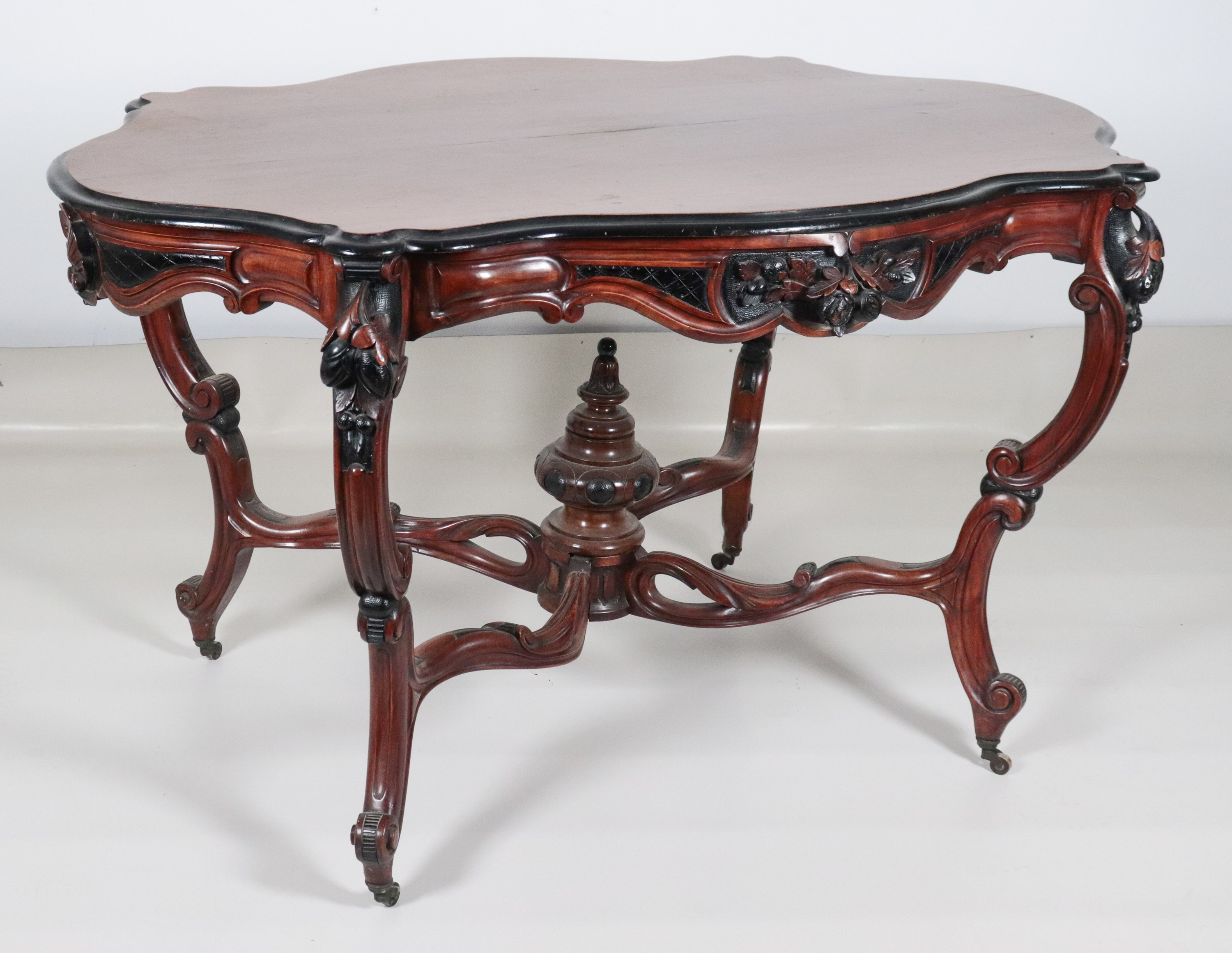 Antico tavolo a rognon Luigi Filippo in noce, con piano ovale sagomato ed intagli ebanizzati a mo...