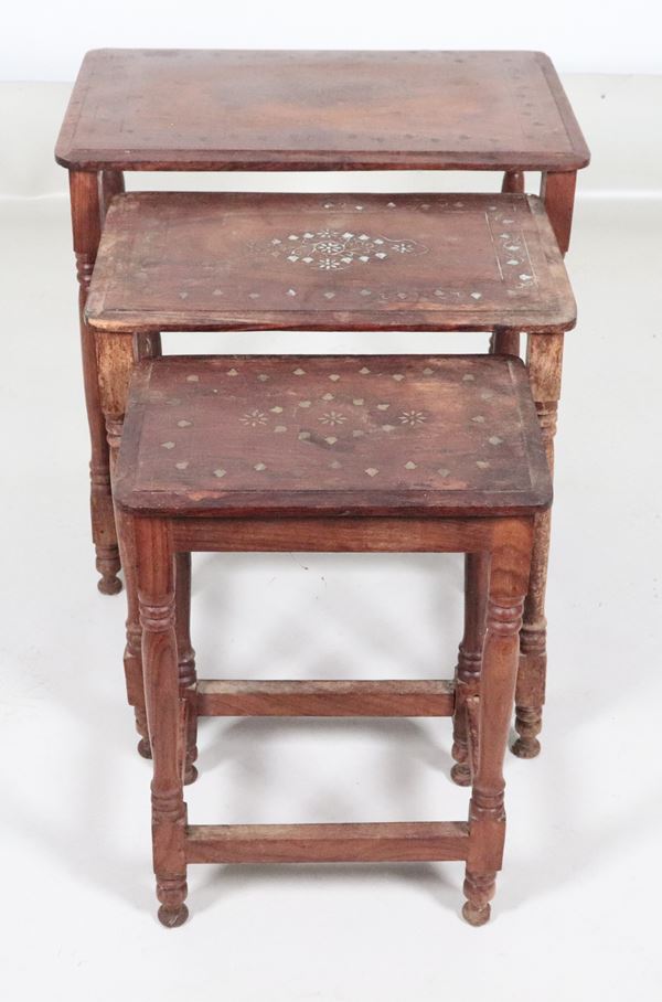 Nido di tre tavolinetti orientali in noce, con intarsi a motivi di volute e stelle