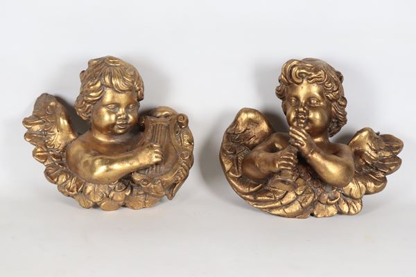 Coppia di putti suonatori in legno dorato e intagliato
