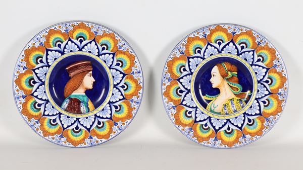 Coppia di piatti da muro in maiolica smaltata Faenza, con decorazioni policrome a motivi di fogliame, al centro ritratti di nobiluomo e nobildonna cinquecenteschi