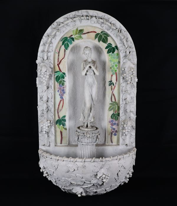 Fontana da muro di gusto Liberty in cartapesta, resina e polvere di gesso, con scultura di vestale e grappoli d'uva a rilievo