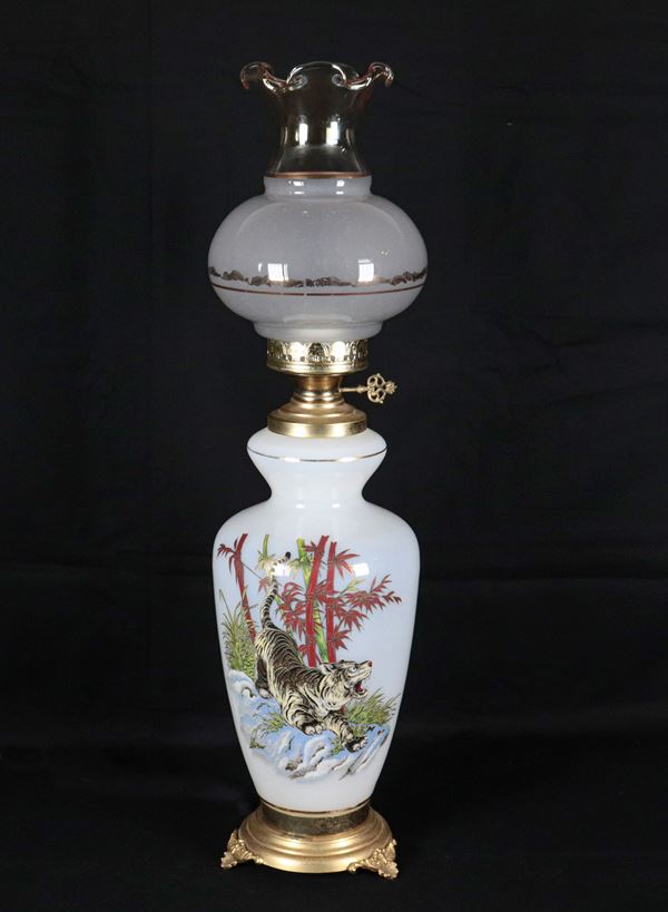 Lampada a petrolio in vetro lattimo, con decorazione smaltata a rilievo di tigre e canne di bamboo, base in metallo dorato