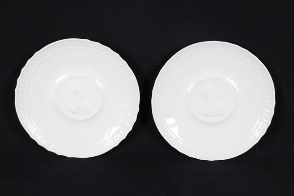 Coppia di piccoli piatti da muro in porcellana bianca Richard Ginori, al centro medaglioni a rilievo con profili di personaggi