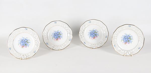 Lotto di quattro piccoli piatti da dolce in porcellana tedesca con bordi traforati, al centro decorazioni con mazzetti di fiori