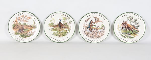 Lotto di quattro piccoli piatti da muro in porcellana, con decorazioni a motivi di animali