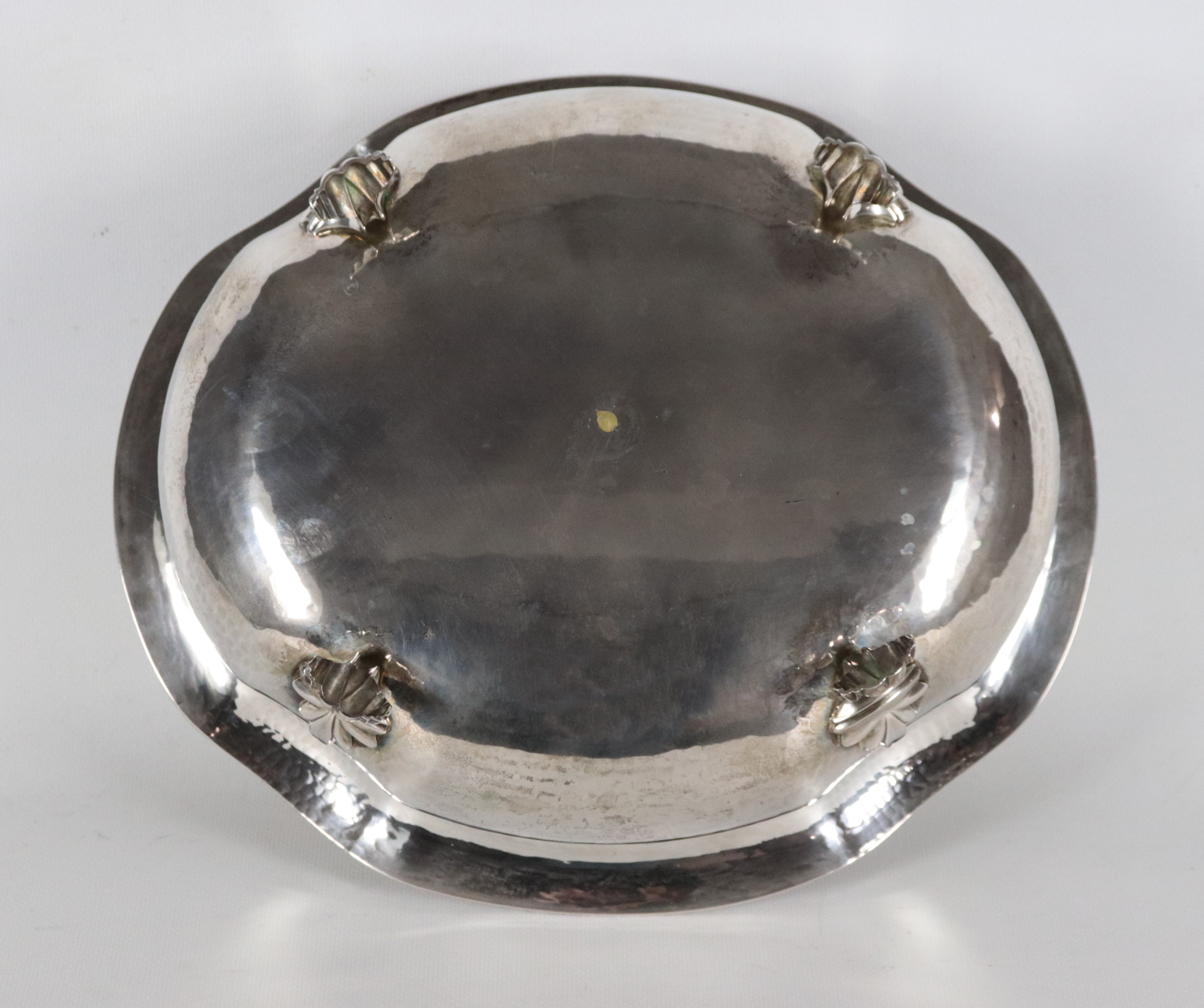 Fruttiera ovale in argento con bordo centinato, cesellato e sbalzato, sorretta da quattro piedini...