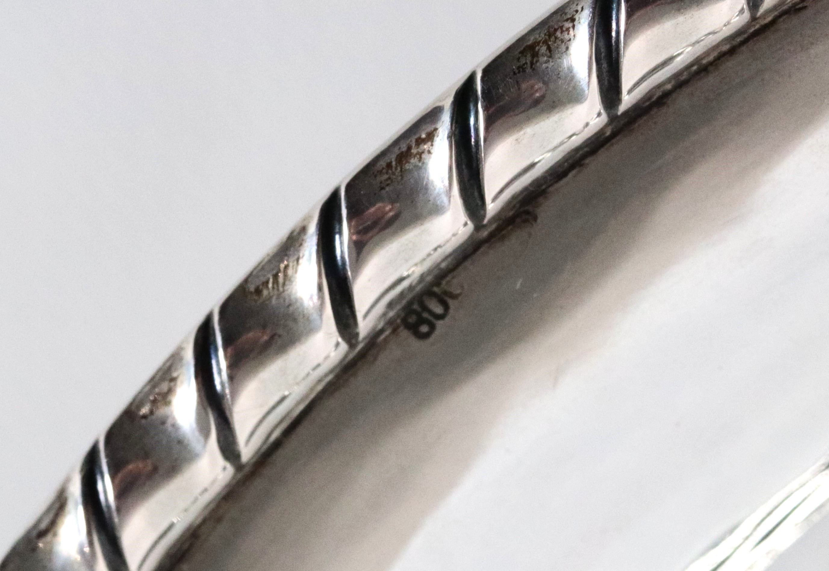 Fruttiera ovale in argento con bordo centinato, cesellato e sbalzato, sorretta da quattro piedini...