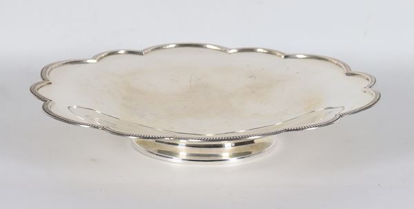 Fruttiera tonda in argento con bordo frastagliato sbalzato e cesellato, sorretta da base circolare, gr. 430