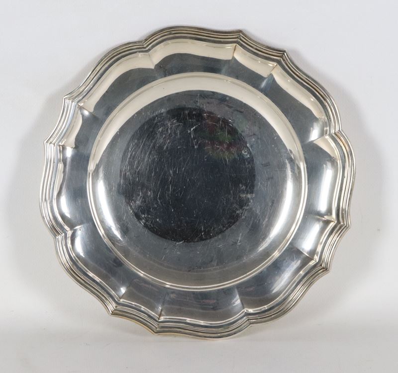 Piatto tondo in argento con bordo centinato, sbalzato e cesellato, gr. 720