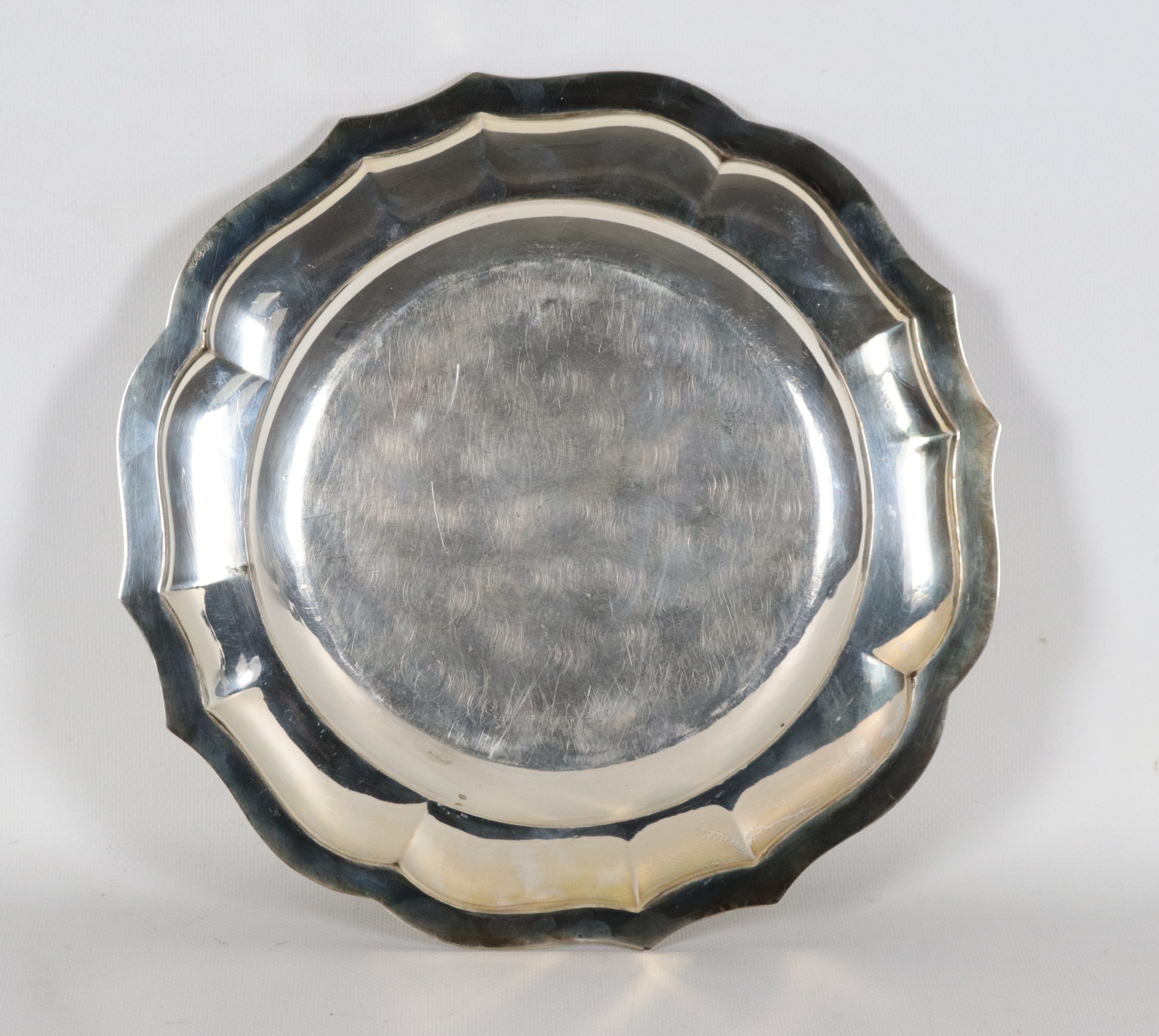 Piatto tondo in argento con bordo centinato, sbalzato e cesellato, gr. 720